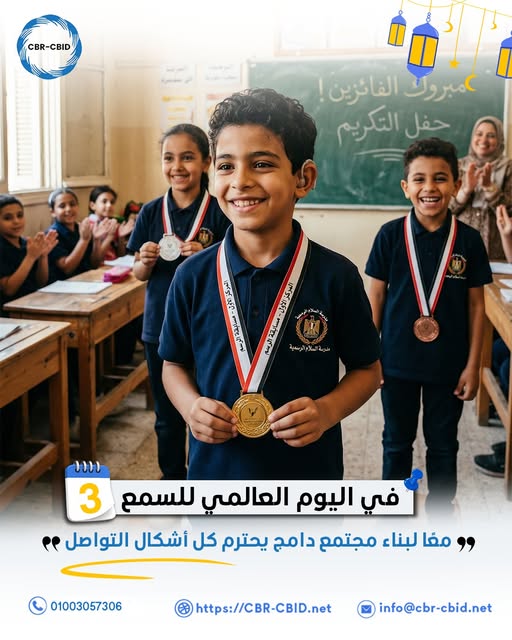 داخل فصل دراسي يقف طفل في المقدمة مبتسمًا ويرتدي زيًا مدرسيًا داكن اللون، وعلى عنقه ميدالية ذهبية يمسكها بيديه. خلفه يقف طالبان آخران يرتديان أيضًا ميداليات فضية وبرونزية ويبدوان سعداء. بقية الطلاب يجلسون على المقاعد ويصفقون احتفالًا بالفائزين، بينما تقف المعلمة في الخلف مبتسمة وتشجعهم. تظهر على السبورة خلفهم عبارة تشير إلى تكريم الفائزين وحفل التكريم. في أسفل الصورة رسالة توعوية تقول: "في اليوم العالمي للسمع… معًا لبناء مجتمع داعم يحترم كل أشكال التواصل.